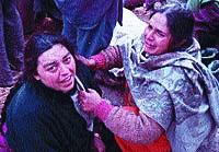 Two women, who lost their relatives, console each other.jpg
