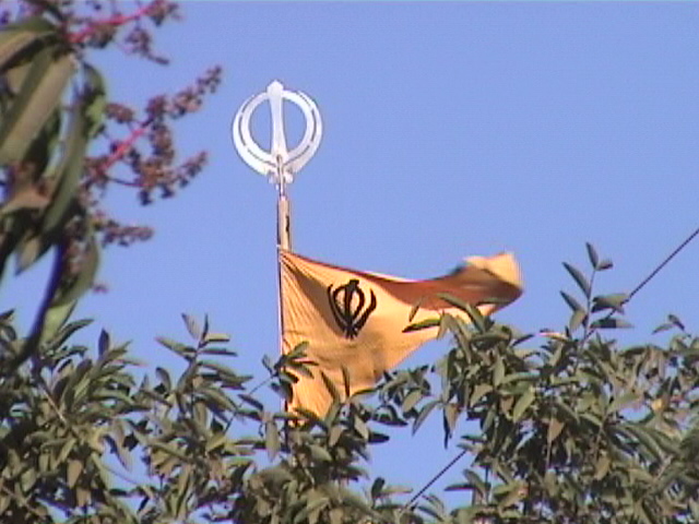 Nishan Sahib Thru Trees. This Nishan Sahib is changed anytime someone wishes to do the sewa. (circa 2002)