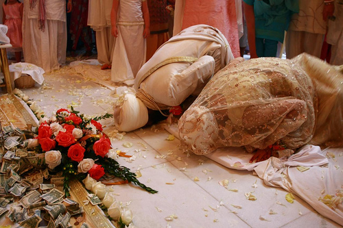 The bride and bridegroom bowing to the Guru