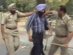 Phase VIII Station House Officer (SHO) Sub-Inspector Kul Bhushan grabs the young Sikh before desecrating his turban